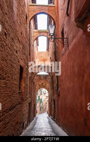 Ancienne rue étroite avec plusieurs passages à l'étage, à Sienne, Toscane, Italie Banque D'Images