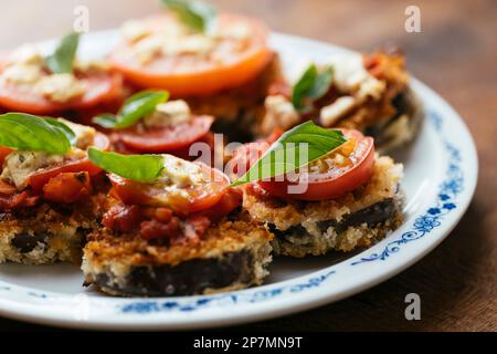 Piles d'aubergines panées avec sauce tomate, tranche de tomate et feta de Vega Banque D'Images