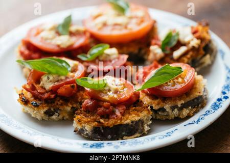 Piles d'aubergines panées avec sauce tomate, tranche de tomate et feta de Vega Banque D'Images