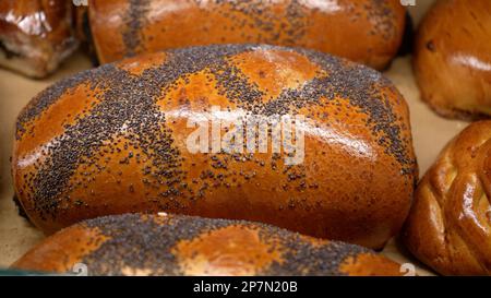 Des rangées de petits pains frais chauds sont en démonstration dans le kiosque de boulangerie de l'épicerie locale Banque D'Images