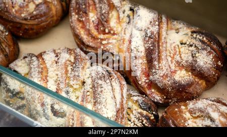 Des rangées de petits pains frais chauds sont en démonstration dans le kiosque de boulangerie de l'épicerie locale Banque D'Images