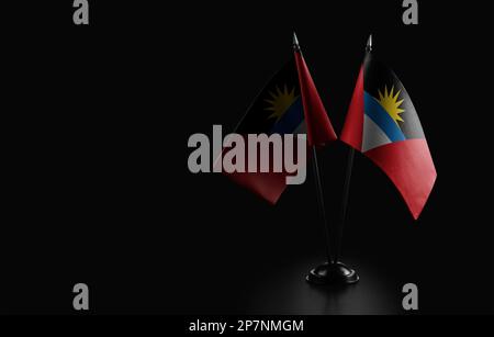 Petits drapeaux nationaux d'Antigua-et-Barbuda sur fond noir. Banque D'Images