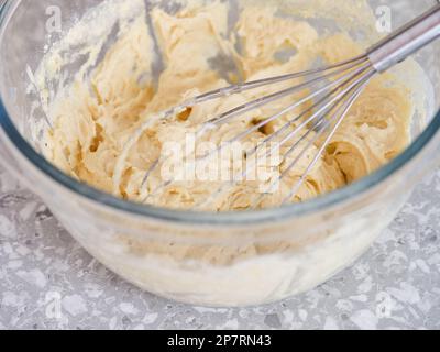 Une pâte à tarte sans gluten dans un bol en verre avec un fouet. Gros plan. Banque D'Images