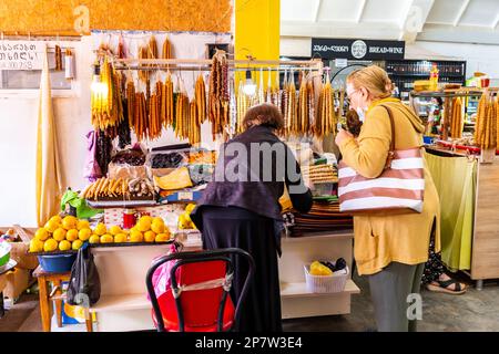 Kutaisi, Géorgie, 04.06.21. Marché avec des bonbons et des légumes locaux, dame vendant des produits au client dans le marché central de Kutaisi (marché vert). Banque D'Images