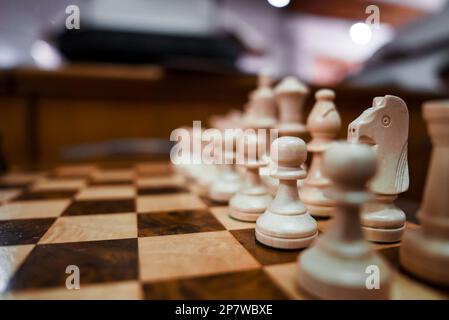 Pièces d'échecs en bois blanc disposées sur un échiquier dans l'hôtel Banque D'Images