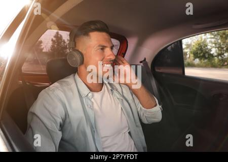 Homme écoutant de la musique dans un taxi moderne Banque D'Images