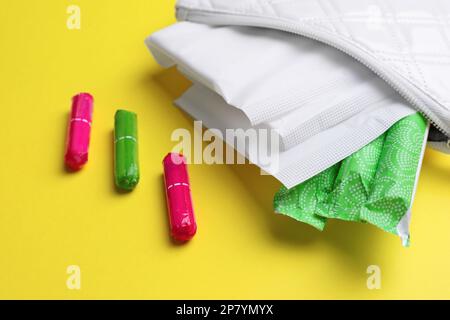 Sac avec tampons et tampons menstruels sur fond jaune, gros plan Banque D'Images