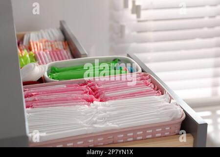 Ouvrez le tiroir de l'armoire avec les tapis menstruels, les tampons et les pantyliners à l'intérieur, en gros plan Banque D'Images