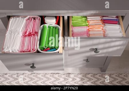 Ouvrez les tiroirs de l'armoire avec les tapis menstruels, les tampons et les pantyliners à l'intérieur, au-dessus de la vue Banque D'Images