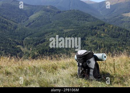 Sac à dos et somnifères dans les montagnes le jour ensoleillé, espace pour le texte Banque D'Images