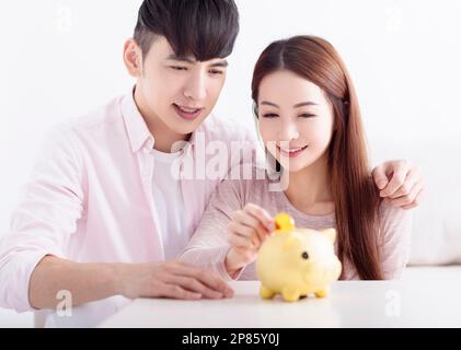 Jeune couple tenant Piggybank et faisant des économies pour l'avenir Banque D'Images