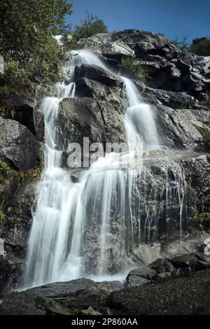 Cascade descendant des rochers le long du sentier de randonnée de Wapama Falls dans le parc national de Yosemite. Banque D'Images