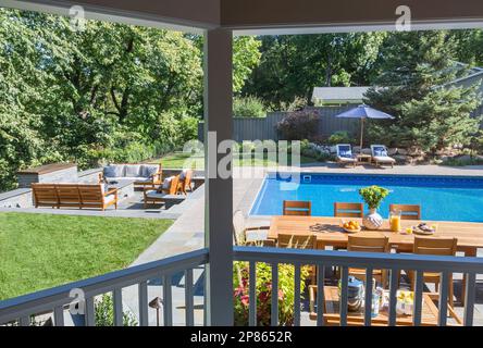 Extérieur d'une maison avec zone de foyer en contrebas et piscine extérieure Banque D'Images