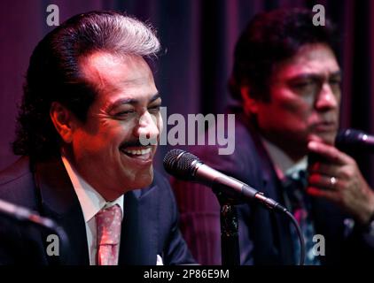 Hernan Hernandez, left, smiles as Jorge Hernandez looks on during a news conference for their band Los Tigres Del Norte in Los Angeles, Wednesday, Aug. 12, 2009. (AP Photo/Matt Sayles)