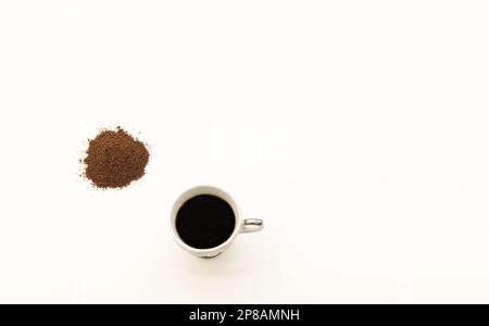 café moulu avec une tasse de café sur fond blanc Banque D'Images