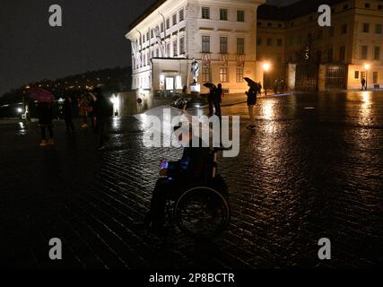 Minuit. 8th mars 2023. La chute de la norme présidentielle et la fermeture de la porte des géants au château de Prague ont symboliquement mis fin au mandat de dix ans du président tchèque Milos Zeman à minuit, mercredi, 8 mars 2023. Au cours de la cérémonie de plusieurs minutes, la Garde du Château de Prague a joué l'hymne national. Ce matin, le successeur de Zeman, Petr Pavel, sera assermenté. Environ 100 personnes se sont rassemblées sur la place Hradcanske sous la pluie (photo), dont certaines buvaient du champagne et chantaient « enfin » à minuit. Crédit : Michal Krumphanzl/CTK photo/Alay Live News Banque D'Images