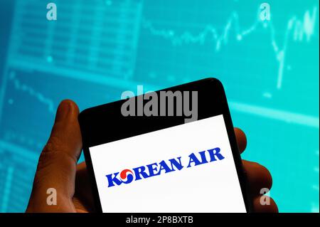Dans cette illustration, le logo de la plus grande compagnie aérienne et porte-drapeau de Corée du Sud, Korean Air, est affiché sur un smartphone avec un graphique d'indice boursier économique en arrière-plan. Banque D'Images