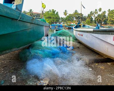 Sinquerim, Goa, Inde - janvier 2023 : filets de pêche colorés et bateaux de pêche sur les rives du fleuve Nerul dans le village de Sinquerim. Banque D'Images