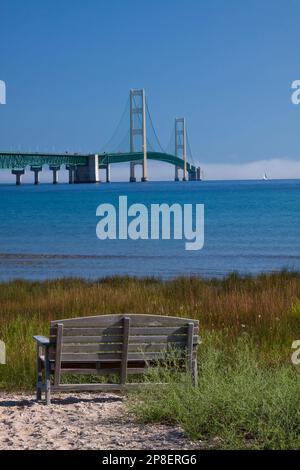Un long pont suspendu avec banc de stationnement en premier plan. Banque D'Images