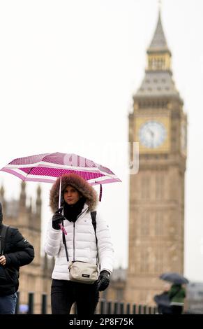 Les membres du public se protègent de la pluie sous des parasols sur le pont Westminster à Londres. Date de la photo: Jeudi 9 mars 2023. Banque D'Images