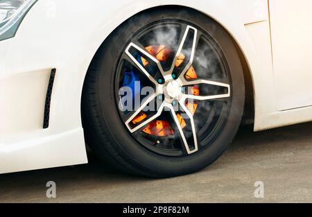 Gros plan d'un frein à disque en feu dans une roue d'une voiture de sport. Banque D'Images