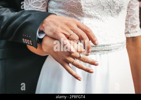 Photo en gros plan des mains de la mariée et du marié, ornée d'anneaux de mariage. La beauté de leurs doigts entremêlés. Anneaux sur la main de la br Banque D'Images