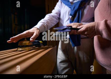 Un homme vêtant de façon décontractée appelle le personnel de l'hôtel pour s'inscrire Banque D'Images