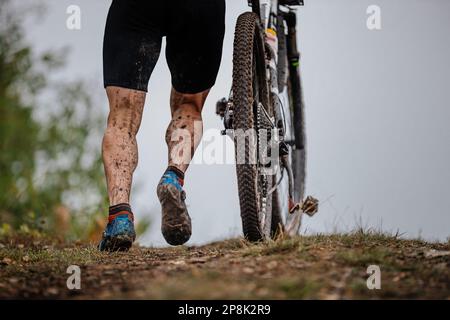 l'athlète monte avec son vtt. laisse tomber la saleté sur les pieds et le vélo. compétition de cyclisme de fond Banque D'Images