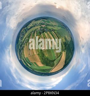 Vue aérienne depuis la haute altitude de la petite planète Terre avec des champs agricoles verts et jaunes cultivés avec des cultures en pleine journée d'été. Banque D'Images