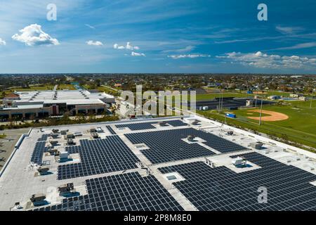 Vue aérienne de la centrale solaire avec panneaux photovoltaïques bleus montés sur le toit de bâtiment industriel pour produire de l'électricité écologique verte. Produit Banque D'Images