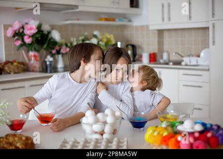 Enfants, frères et sœurs, œufs de coloriage pour Pâques à la maison Banque D'Images