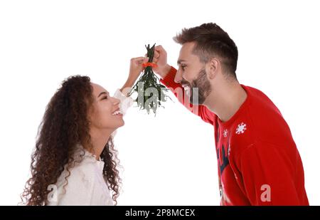 Couple charmant sous le bouquet de GUI sur fond blanc Banque D'Images