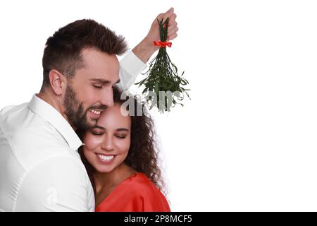 Couple charmant sous le bouquet de GUI sur fond blanc Banque D'Images