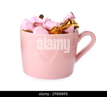 Tasse avec bonbons dans des emballages colorés isolés sur blanc Banque D'Images