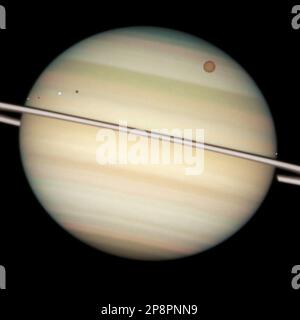 This image provided by NASA is a Hubble Space Telescope close-up view of Saturn's disk captures the transit of several moons across the face of the gas giant planet. The giant orange moon Titan – larger than the planet Mercury – can be seen at upper right. The white icy moons close to the ring plane are, from left,Enceladus, Dione, and Mimas, at right edge of the plaent. The dark band running across the face of the planet slightly above the rings is the shadow of the rings cast on the planet. The dark dots as the shadows cast by Enceladus and Dione. (AP Photo/NASA)