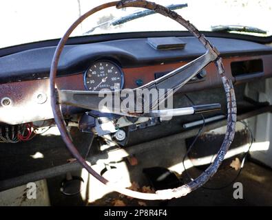 Tableau de bord d'une voiture épave avec volant en rotation, verrou d'allumage et compteur de vitesse Banque D'Images
