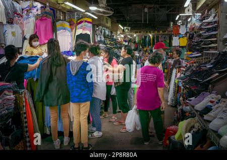 Une foule de consommateurs se balader à travers des vêtements dans une cabine du marché russe de Phnom Penh, au Cambodge. Banque D'Images