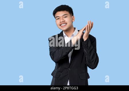 Jeune homme d'affaires asiatique souriant fier de clapping isolé sur fond bleu clair Banque D'Images
