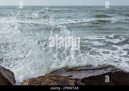 Une photo du surf marin. Éclaboussures d'eau sur la pierre. Surfez sur l'océan entre les rochers. Arrière-plan de la marée Banque D'Images