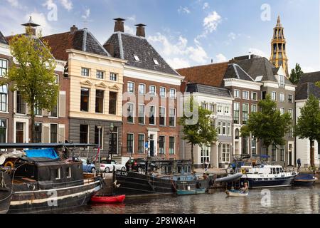 Les maisons de canal et les entrepôts sur le vieux port à la Hoge der A avec la tour de l'église historique Der AA à Groningen en arrière-plan. Banque D'Images