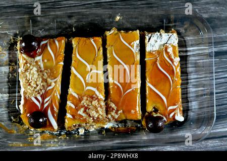 Dessert égyptien composé de couches de gâteau de la semoule de basbousa, kunafa knafeh, crème fouettée, sauce au caramel, imbibées de sucreries et superposées de noix, Banque D'Images