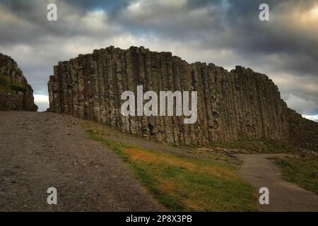 Colonnes de basalte sur la chaussée des géants, en Irlande du Nord, avec un ciel nuageux et spectaculaire Banque D'Images