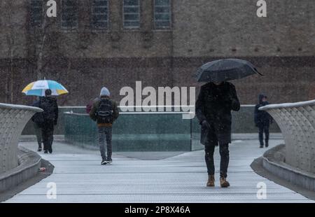 © Jeff Moore les navetteurs sur la passerelle du millénaire de Londres font leur chemin pour travailler ce matin dans des conditions enneigées . Banque D'Images