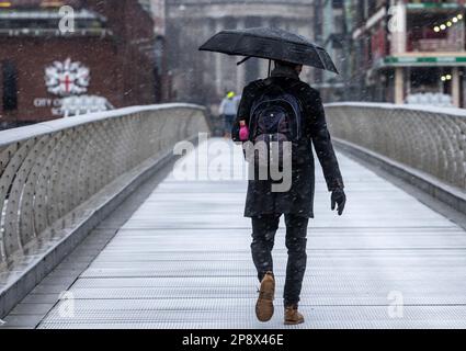 © Jeff Moore les navetteurs sur la passerelle du millénaire de Londres font leur chemin pour travailler ce matin dans des conditions enneigées . Banque D'Images