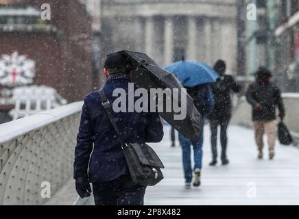 © Jeff Moore les navetteurs sur la passerelle du millénaire de Londres font leur chemin pour travailler ce matin dans des conditions enneigées . Banque D'Images