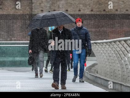 © Jeff Moore les navetteurs sur la passerelle du millénaire de Londres font leur chemin pour travailler ce matin dans des conditions enneigées . Banque D'Images