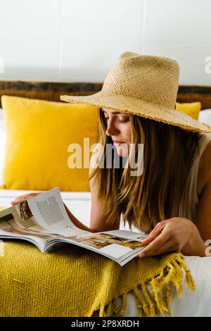 Une femme se pose sur le lit de sa chambre d'hôtel Banque D'Images