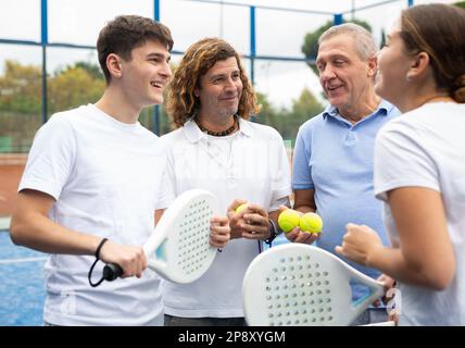 Quatre joueurs de paddle-tennis qui parlent sur le court Banque D'Images