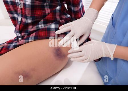 Médecin examinant la hanche contusionnée du patient à l'hôpital, en gros plan Banque D'Images