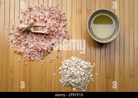 Un studio plat photo d'une pile de sel de mer de l'himalaya avec une pelle, un tas de viande d'avoine séchée, et un petit bol avec de l'huile d'olive. Banque D'Images